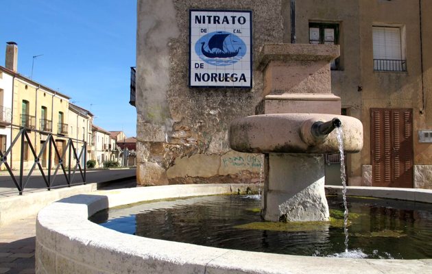 Fuente el caño redondo junto al cartel antiguo de nitratos de Noruega